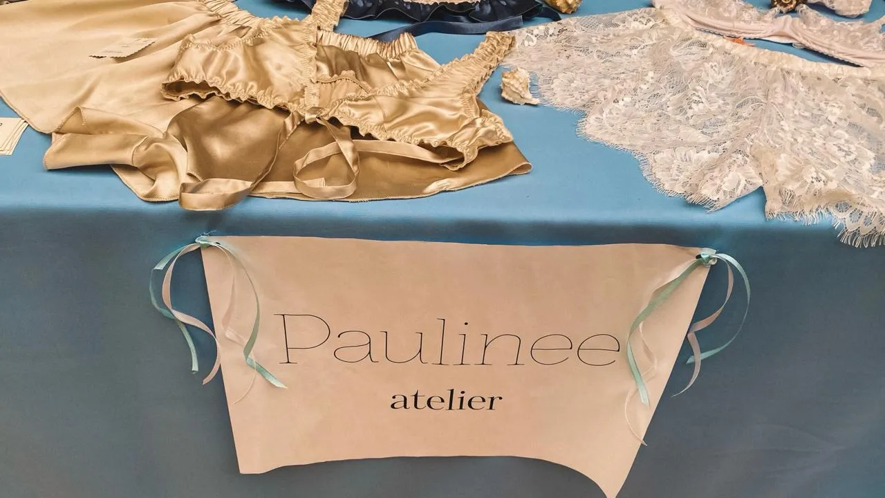 Natpis Paulinee atelier na stolu sa satenskim i čipkanim donjim vešom