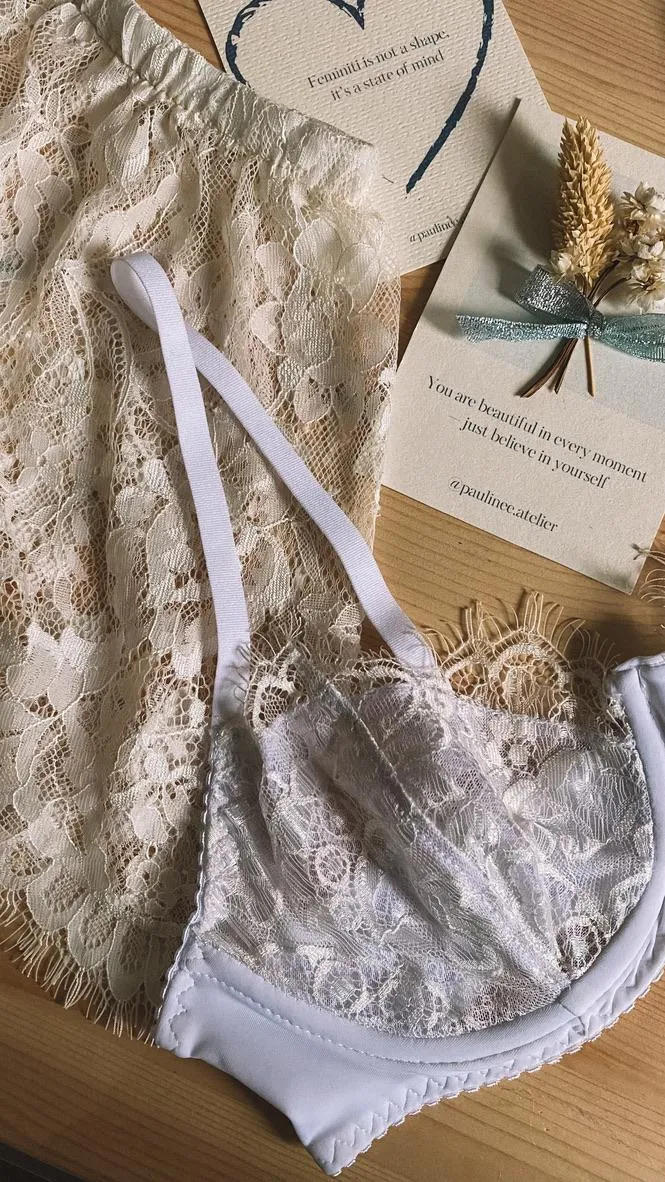 Beli čipkani šorc i grudnjak na stolu, uz kartice sa porukama